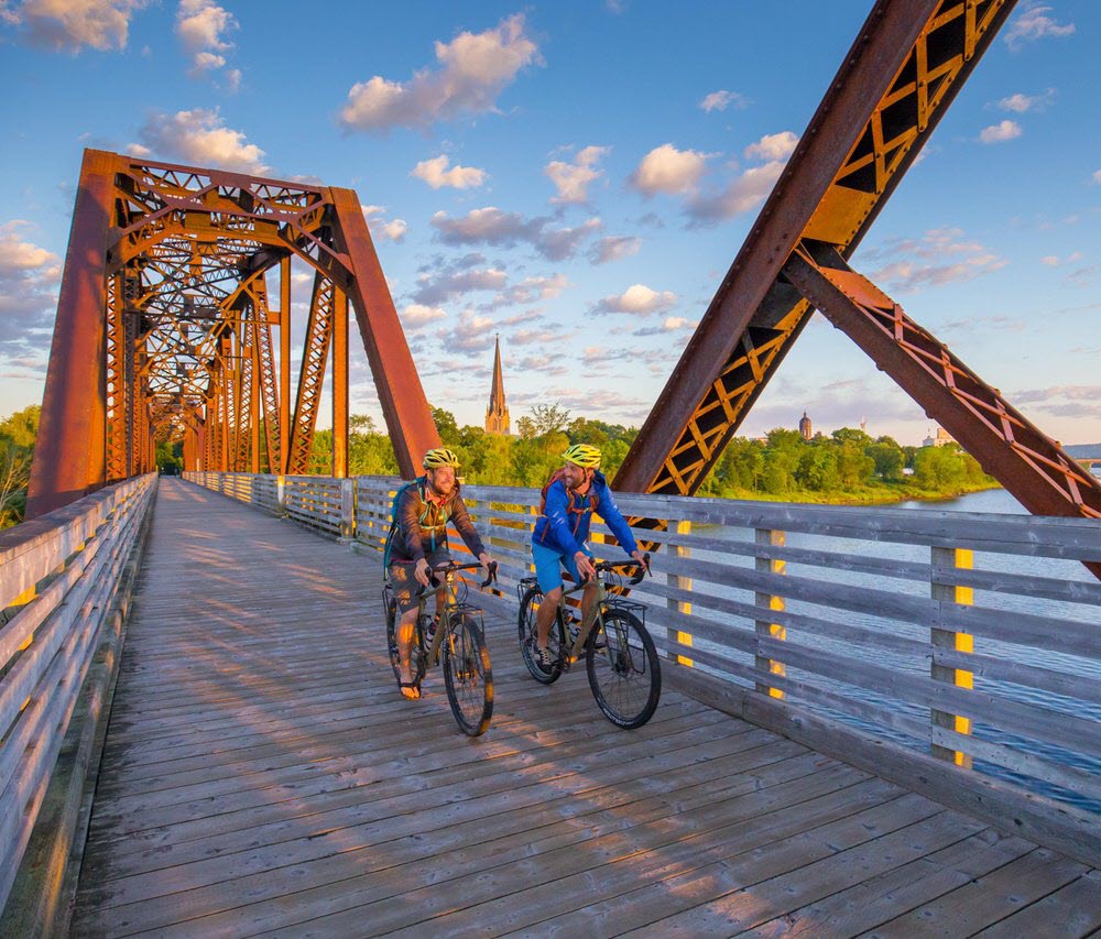 Peoply biking on Bill Thorpe Walking Bridge above the Saint John River.